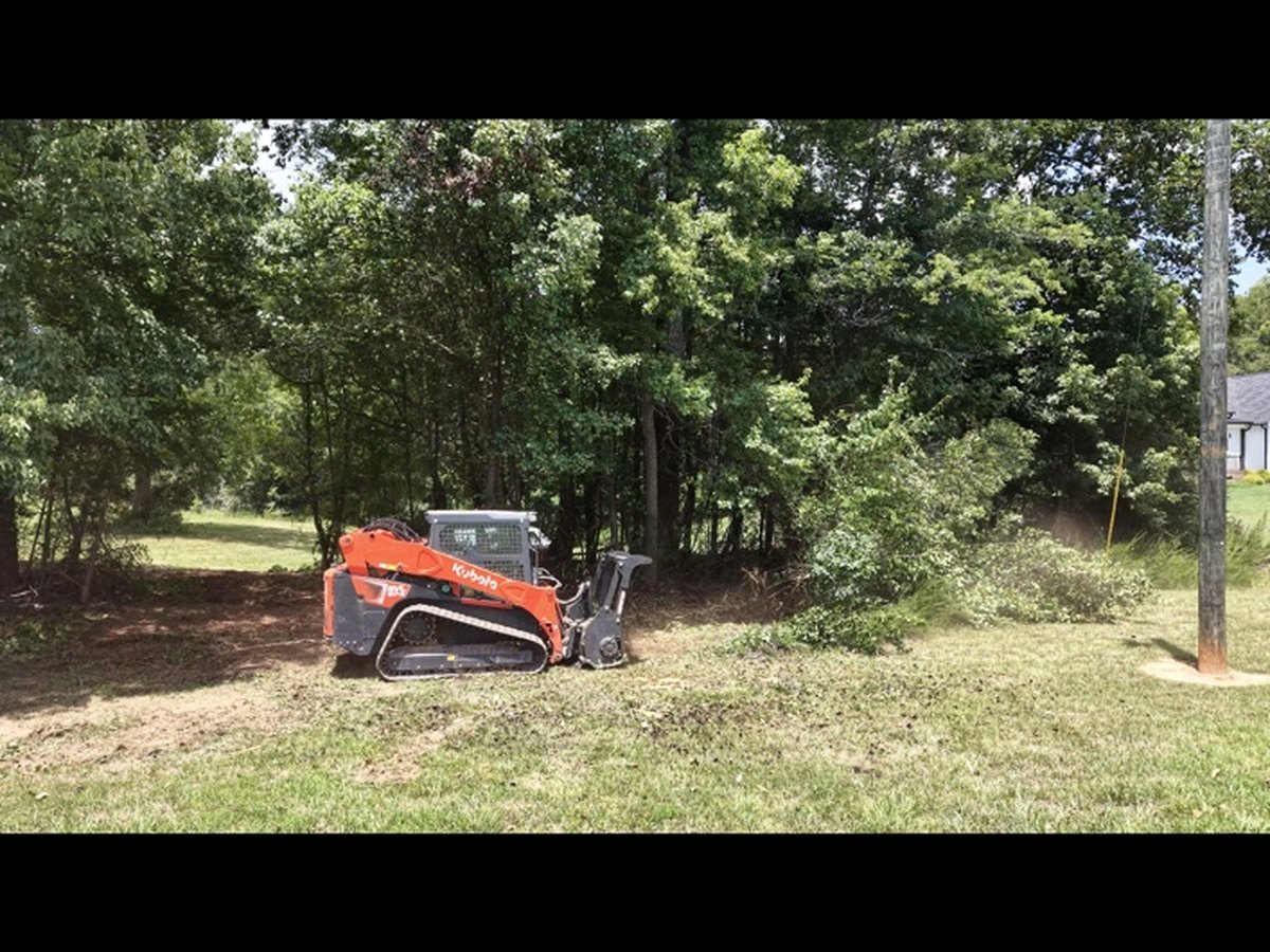 Kubota skid steer performing land management work